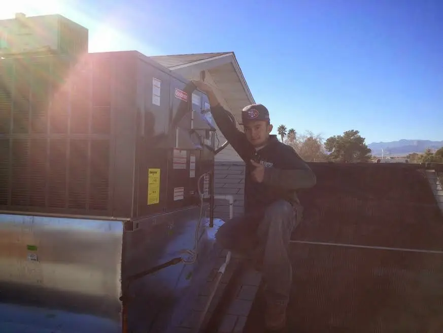 HVAC technician performing AC Tune-Up on a rooftop unit in Centreville